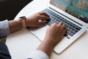 Close-up of hands typing on a laptop, representing digital literacy and online learning
